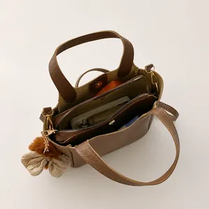 Macro view of brown lychee leather handbag showing large capacity and inner compartments