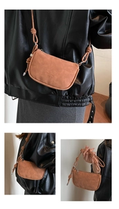 Detail view of tan crossbody bag showing knotted strap and textured matte material
