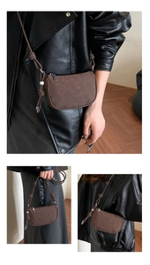 Detail of a brown suede crossbody bag with decorative knotted strap and brand embossing