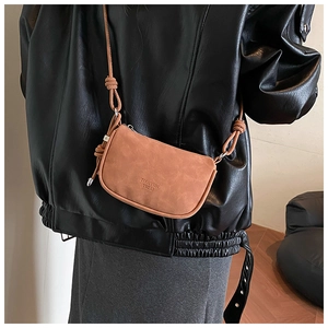 Detail of camel suede half-moon crossbody bag with knot strap and branded logo