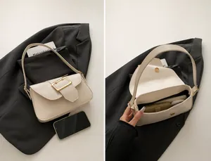 Vue macro du sac blanc crème en cuir PU montrant la poche principale et la boucle dorée