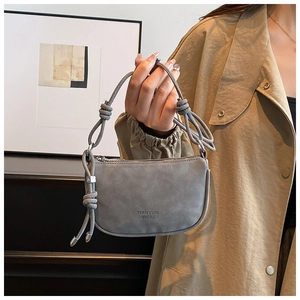 Macro shot of grey matte mini bag featuring distinctive knotted rope handle and silver buckle