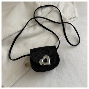Détail du sac selle en cuir grainé noir avec un fermoir métallique argenté en forme de coeur