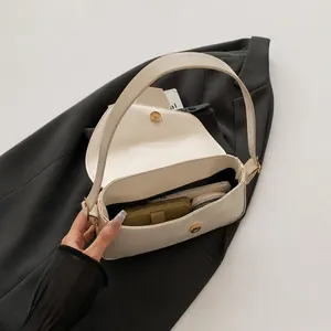 Detailed internal capacity view of the beige leather bag with gold hardware buckle