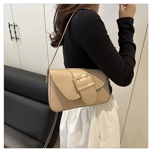 Détail du sac à bandoulière beige avec une boucle carrée dorée sur le rabat en cuir