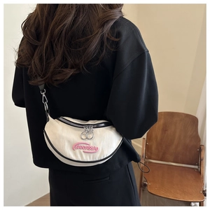 Dettaglio della borsa a mezzaluna in tela bianca con bordo nero e doppia zip in metallo