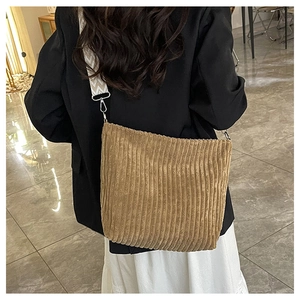 Sac bandoulière en velours côtelé avec large sangle géométrique porté par un mannequin