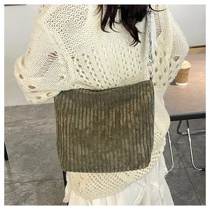 Détail du sac cabas en velours côtelé vert olive avec bandoulière tissée décorative