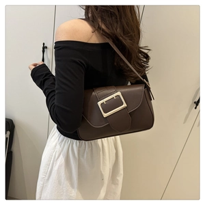 Brown leather crossbody bag featuring a bold gold square buckle on a shoulder strap