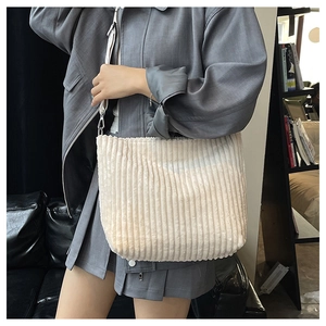 Détail du sac fourre-tout beige en velours côtelé avec rayures et large bandoulière