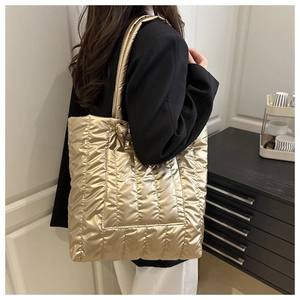 Detailed view of the large gold quilted tote bag with a metallic finish and padded texture