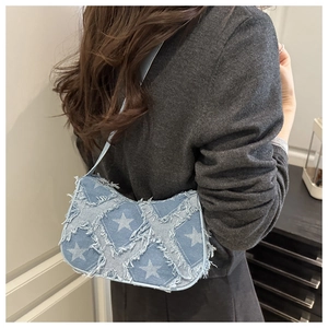 Close-up of denim star crossbody bag featuring frayed edges and stylish chain strap