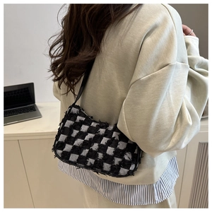 Detail shot of black and white checkerboard tweed shoulder bag with fringe edges