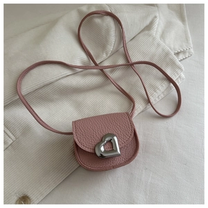 Détail de la texture cuir rose et boucle en métal cœur argenté sur le mini sac