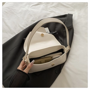 Détail de l'intérieur d'un sac bandoulière blanc montrant le portefeuille et le mobile