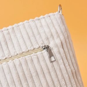 Détail du sac fourre-tout en velours côtelé avec fermeture éclair et anneau métallique