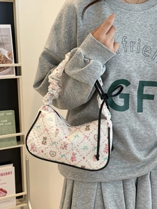 Chic white quilted crossbody bag with bear and rabbit prints on a fashion model
