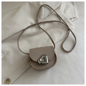 Détail du fermoir coeur argenté sur le mini sac besace kaki à texture litchi