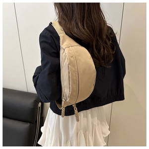 Beige nylon heuptasje crossbody gedragen door een model voor een moderne modieuze uitstraling