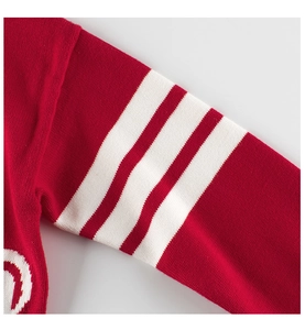 Detail of red knitted sweater sleeve with white stripes and soft fabric texture