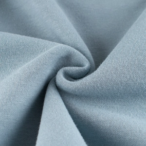 Close-up of light blue-grey knit fabric showing soft texture and premium cotton weave