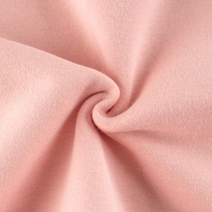 Gros plan sur un tricot rose doux montrant la texture de haute qualité et les détails
