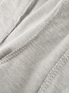 Dettaglio macro del tessuto in maglia di cotone grigio con cuciture curate sui pantaloni