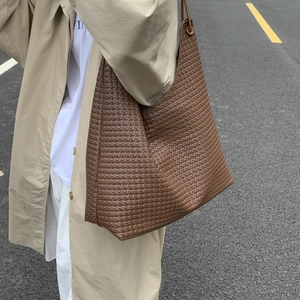 Minimalist vintage woven tote bag in dark brown leather styled for daily commute fashion