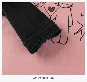 Detail of pink cotton long-sleeve cuff with cute cat print and precise black stitching