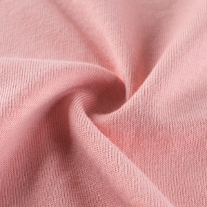 Macro shot of soft pink knit fabric texture with elegant spiral fold design