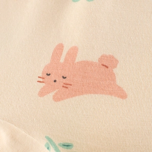 Nahaufnahme von weichem Baumwollstoff mit süßem Hasenprint auf beigen Kinder-Shorts
