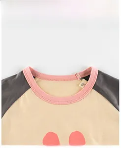 Gros plan du T-shirt raglan enfant en coton avec col rose et étiquette de taille