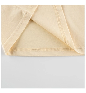 Détail de la double couture sur l'ourlet du t-shirt en coton beige pour filles