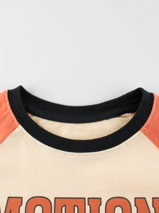 Raglan sleeve T-shirt with MOTION print, cream body with orange sleeves and black neckline
