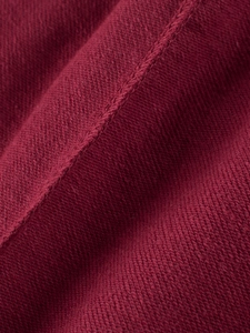 Texture macro du tissu tricoté rouge foncé avec coutures diagonales pour pantalon enfant