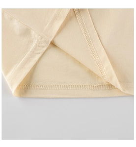 Detailed close-up showing precision double-needle stitching on yellow cotton shirt hem