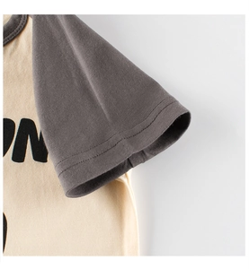 Détail de la double couture sur les manches raglan contrastées d'un t-shirt coton enfant