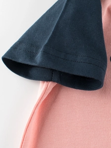 T-shirt in cotone per bambini con corpo rosa e maniche blu scuro e cuciture a contrasto