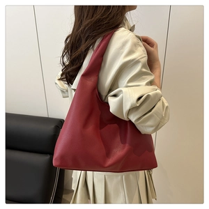 Detail showing the burgundy pebbled leather texture and soft slouchy design of the hobo bag