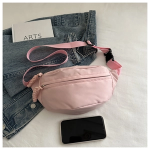 Detailed top view of pink canvas fanny pack with matching zipper and black buckle straps