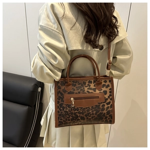 Lifestyle shot of a leopard print crossbody bag worn with a chic autumn trench coat