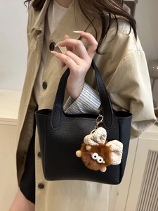 Borsa a secchiello minimalista in pelle martellata nera con ciondolo in peluche morbido