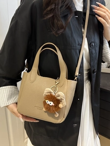 Elegante borsa a secchiello in pelle kaki con ciondolo mostro portata a spalla