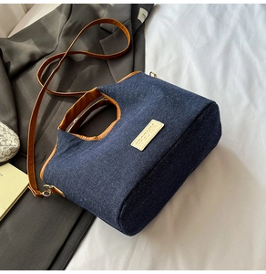 Detail of denim handbag with 3D bear decoration and adjustable brown shoulder strap