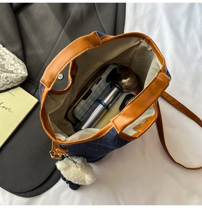 Detail of denim bucket bag interior capacity with 3D teddy bear charm and magnetic closure
