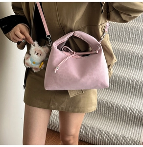Pink bow shoulder bag with soft texture, drawstring closure, and plush dog pendant