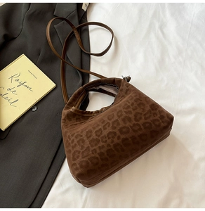 Close-up of leopard print crossbody bag with velvet texture on a minimalist white backdrop