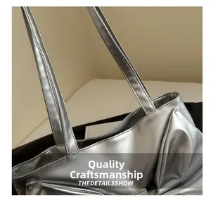Close-up of durable stitching on silver metallic tote bag strap with mirror finish