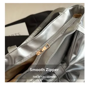 Macro shot of smooth metal zipper and silver faux leather texture on fashionable tote bag
