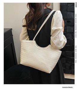 Detail of white large capacity tote bag featuring elegant V-shape woven texture on shoulder